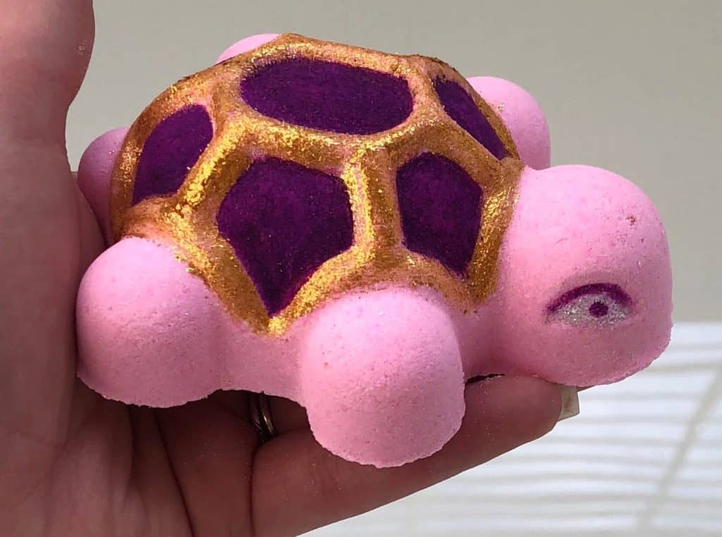 Shimmering Shelly Bubbly bath bomb diy bath bomb without citric acid diy bath bomb easy, handmade pink turtle bath bomb with glitter on the hand in bathroom